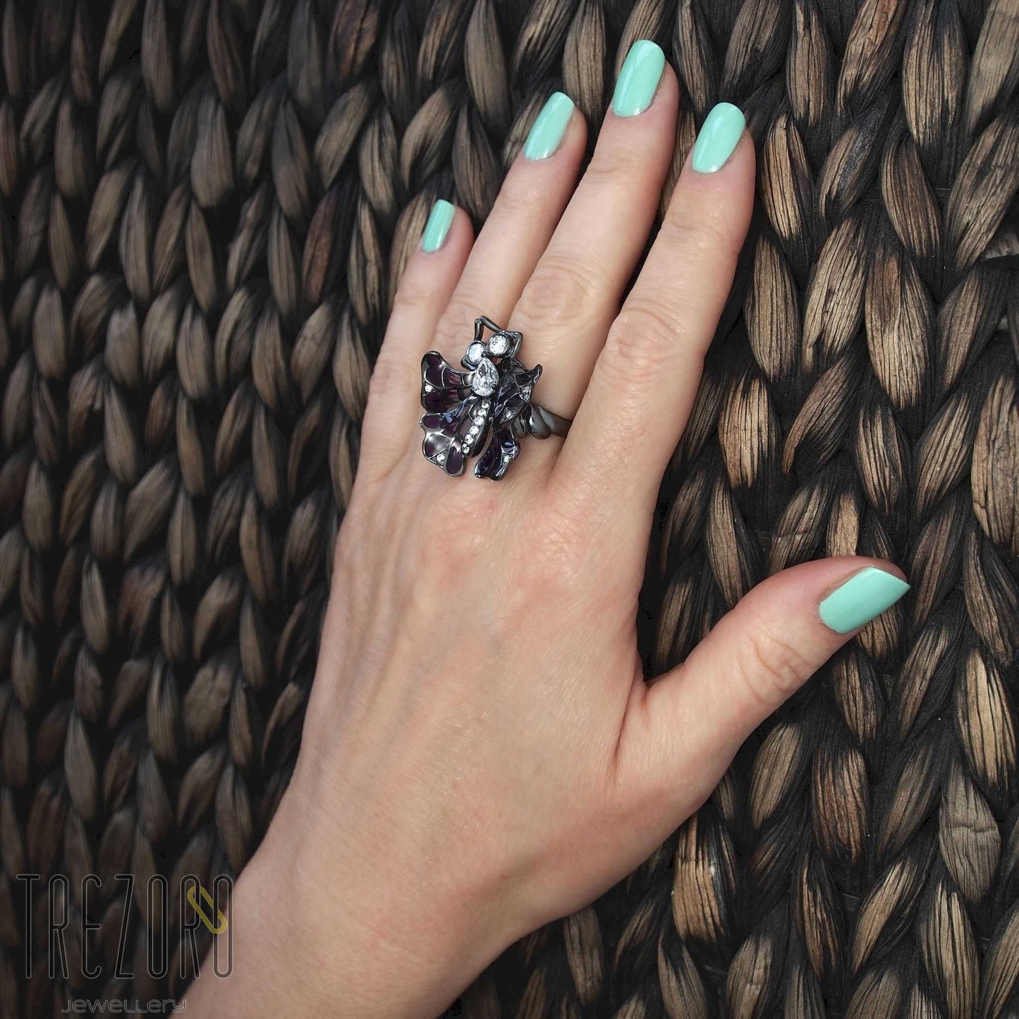 Butterfly oxidised sterling silver Ring with enamel and glass inserts and cubic zirconia worn on a hand.