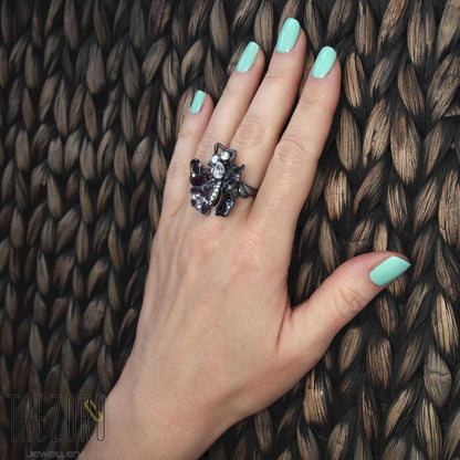 Butterfly oxidised sterling silver Ring with enamel and glass inserts and cubic zirconia worn on a hand.